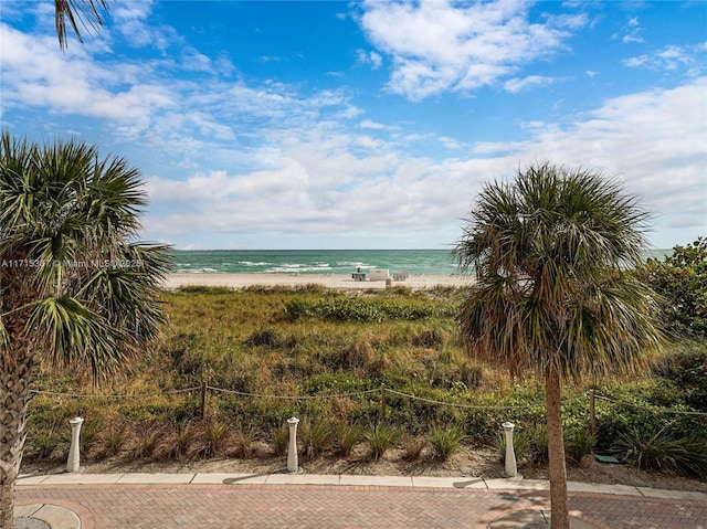 view of water feature featuring a view of the beach and fence
