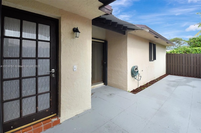 view of exterior entry featuring a patio