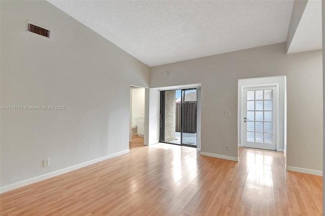 spare room featuring light hardwood / wood-style flooring and a textured ceiling