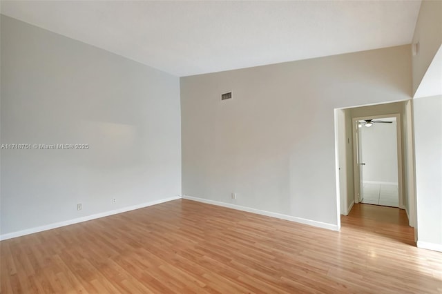 spare room featuring ceiling fan, light hardwood / wood-style floors, and vaulted ceiling