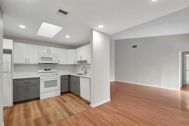 kitchen with white appliances, sink, light hardwood / wood-style flooring, gray cabinets, and white cabinetry