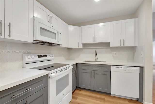 kitchen featuring white cabinetry, sink, light hardwood / wood-style flooring, white appliances, and gray cabinets