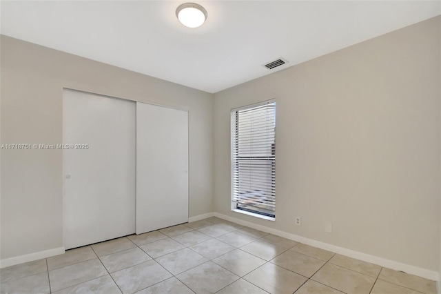 unfurnished bedroom featuring light tile patterned floors and a closet