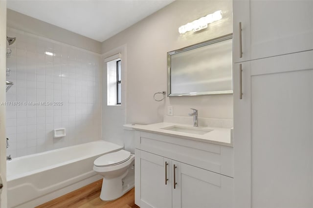 full bathroom featuring vanity, toilet, tiled shower / bath, and hardwood / wood-style flooring