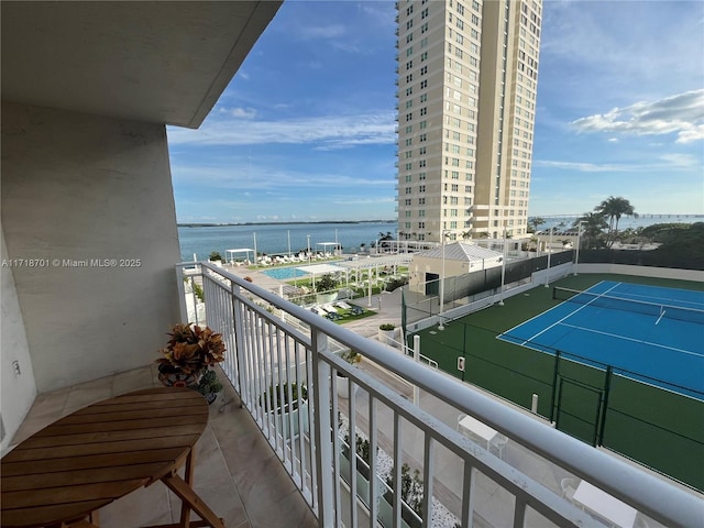 balcony featuring a water view and tennis court