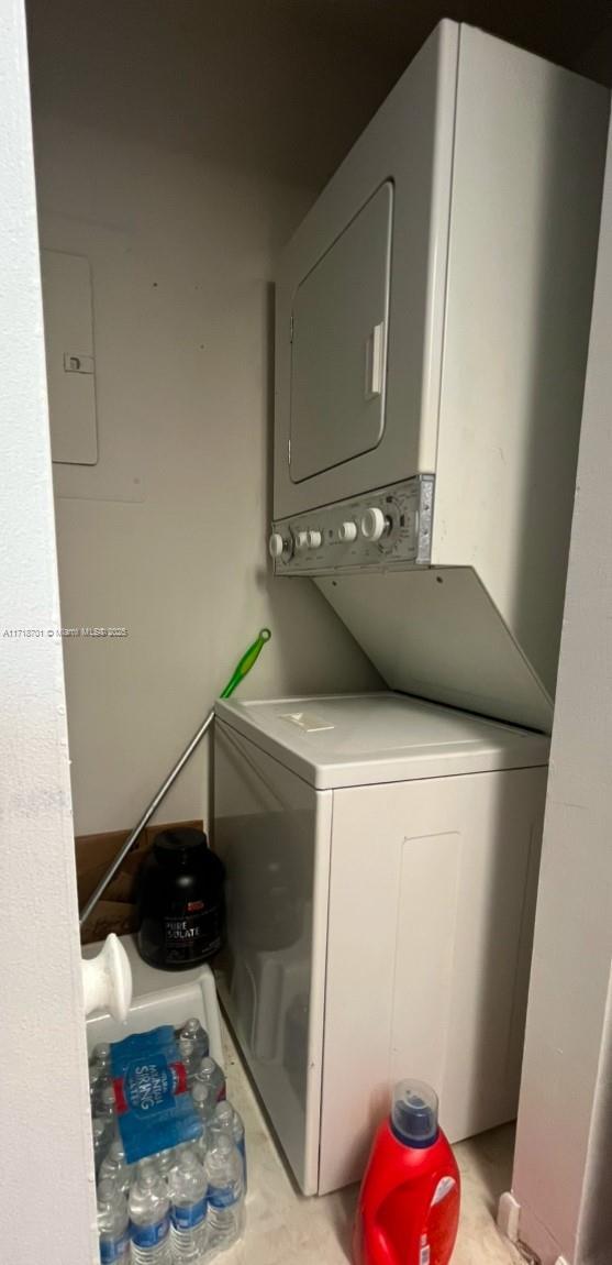 washroom featuring stacked washer and clothes dryer