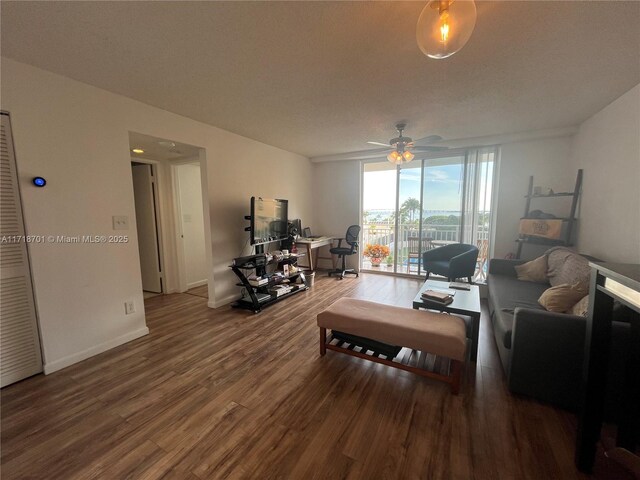 living room with ceiling fan, floor to ceiling windows, and dark hardwood / wood-style flooring