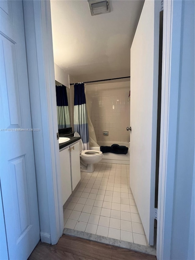 full bathroom with vanity, shower / bath combination with curtain, tile patterned floors, and toilet