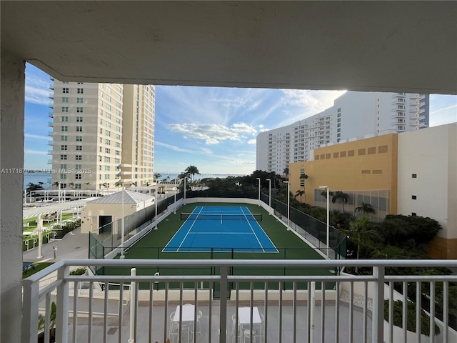 view of sport court featuring a city view and fence