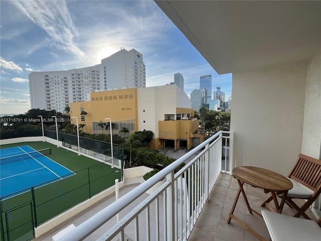 balcony with a tennis court and a view of city