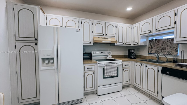 kitchen featuring white appliances, white cabinetry, and sink