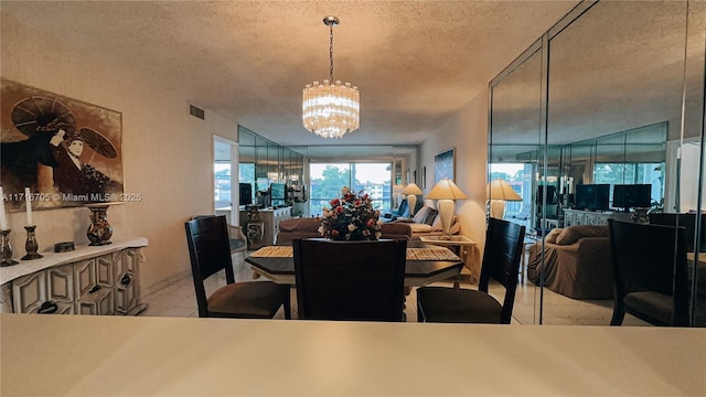 dining space with a textured ceiling and an inviting chandelier