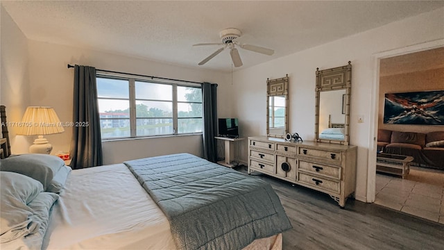 bedroom featuring a textured ceiling, ceiling fan, and dark wood-type flooring