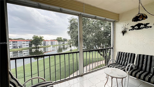 sunroom featuring a water view