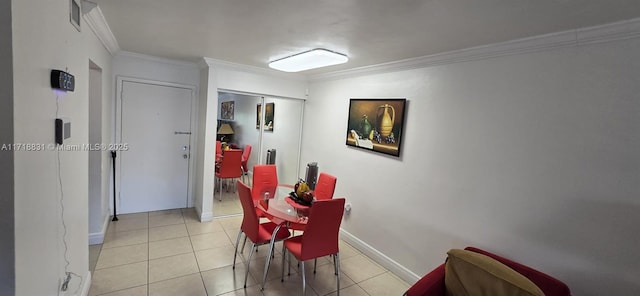 dining area with ornamental molding and light tile patterned floors