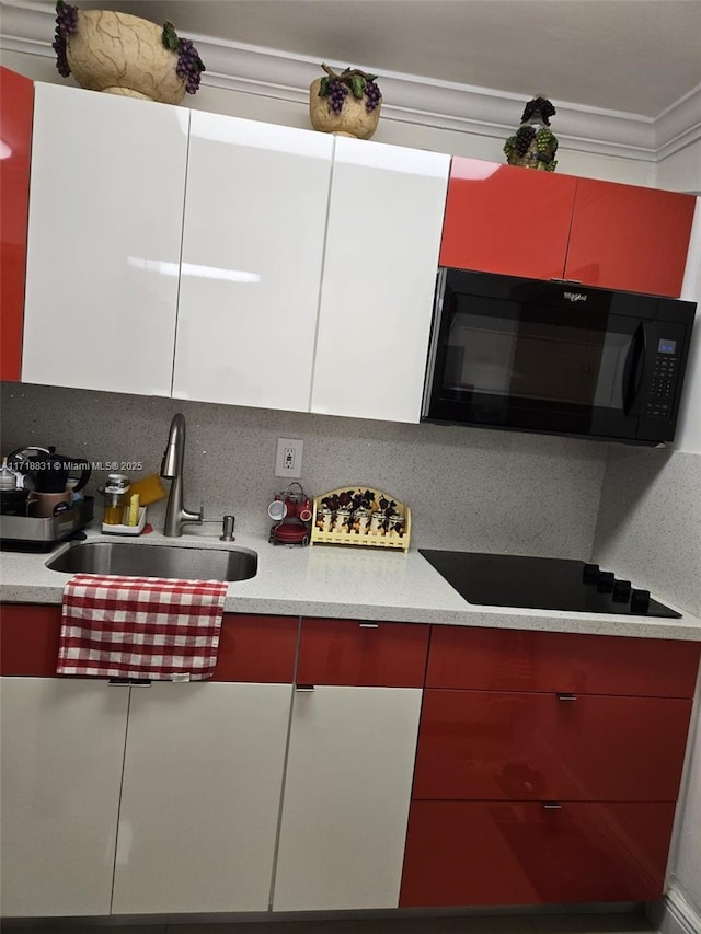 kitchen with backsplash, ornamental molding, sink, black appliances, and white cabinetry