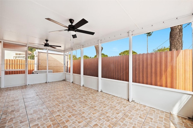 unfurnished sunroom with ceiling fan and a healthy amount of sunlight