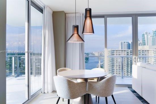 dining area featuring a water view and expansive windows