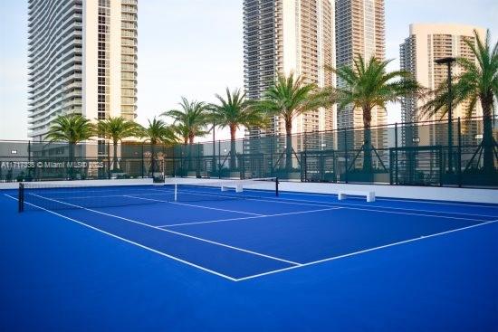 view of tennis court with basketball hoop