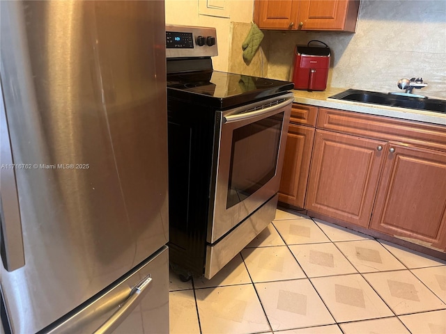 kitchen featuring decorative backsplash, sink, light tile patterned floors, and stainless steel appliances