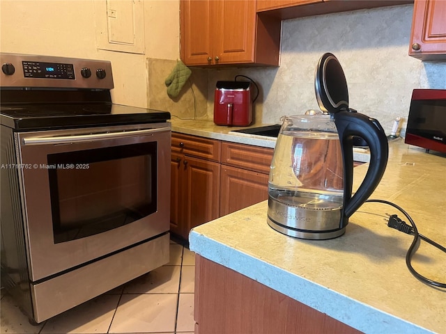 kitchen with electric range and light tile patterned floors