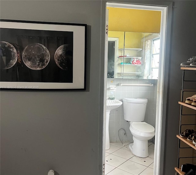 bathroom featuring tile patterned flooring, tile walls, and toilet