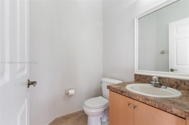 bathroom with toilet, vanity, and tile patterned floors