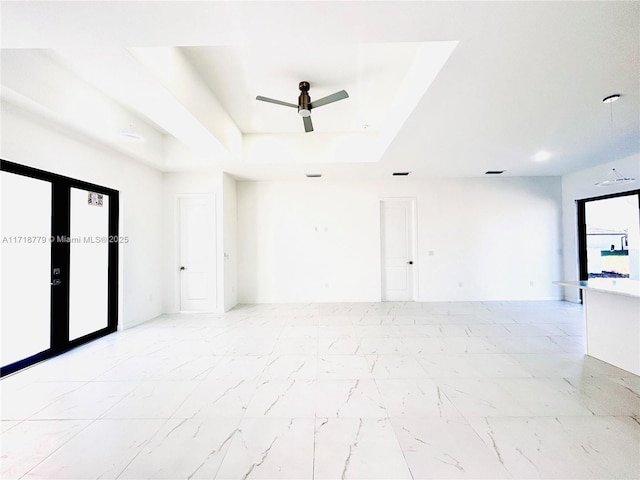 empty room with a tray ceiling and ceiling fan