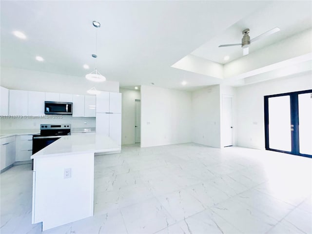 kitchen featuring ceiling fan, decorative light fixtures, a kitchen island, white cabinetry, and stainless steel appliances