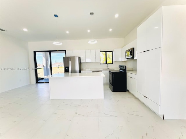 kitchen featuring decorative light fixtures, stainless steel appliances, white cabinetry, and a kitchen island