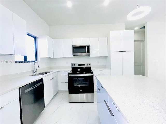 kitchen featuring decorative light fixtures, sink, white cabinetry, and stainless steel appliances