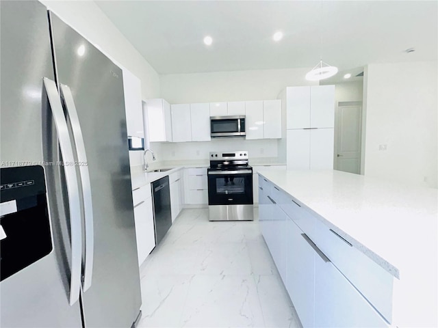 kitchen with white cabinets, stainless steel appliances, hanging light fixtures, and sink