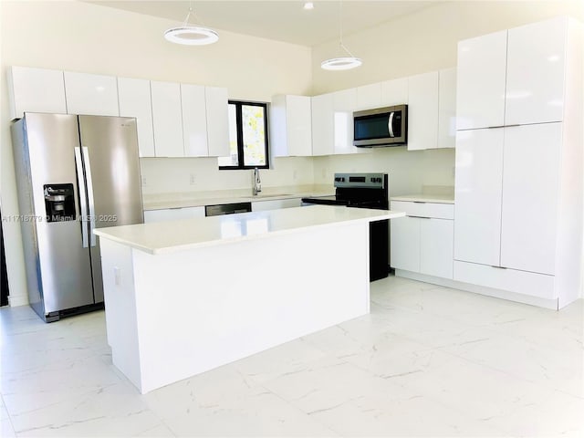 kitchen featuring pendant lighting, a center island, stainless steel appliances, and white cabinetry