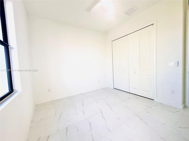 unfurnished bedroom with a closet and ceiling fan