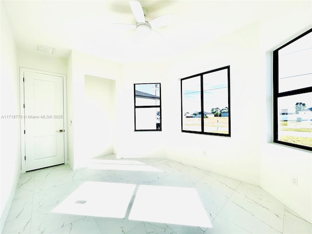 unfurnished room featuring ceiling fan and a wealth of natural light