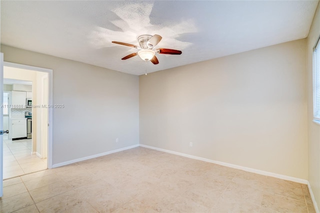 unfurnished room featuring a ceiling fan, a textured ceiling, and baseboards