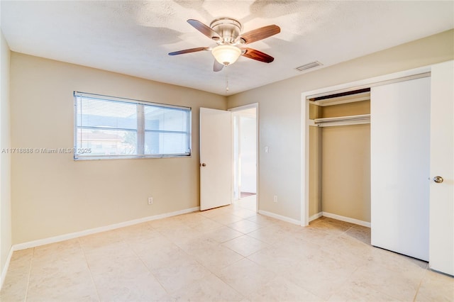 unfurnished bedroom with a textured ceiling, a ceiling fan, visible vents, baseboards, and a closet