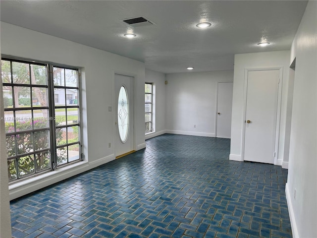 foyer entrance with a textured ceiling