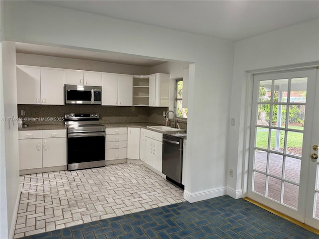 kitchen with white cabinets, decorative backsplash, and stainless steel appliances