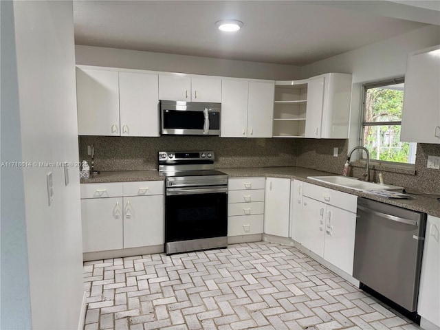 kitchen featuring backsplash, stainless steel appliances, white cabinetry, and sink