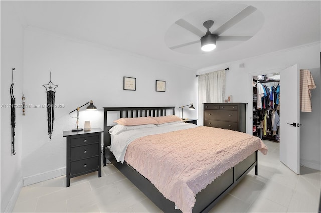 bedroom featuring a walk in closet, ceiling fan, a closet, and crown molding