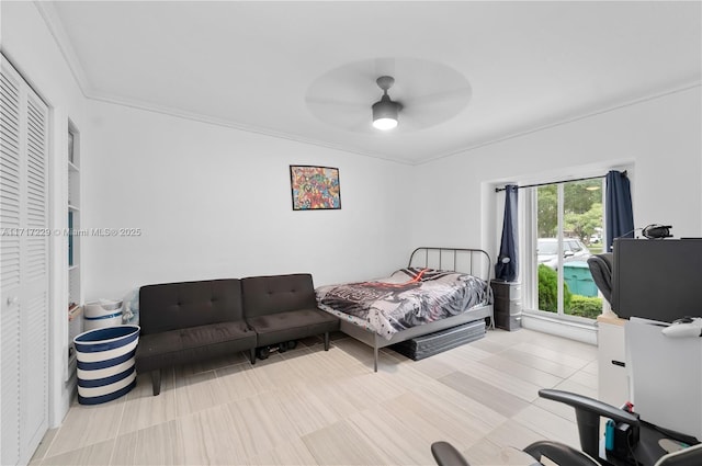 bedroom with ceiling fan, ornamental molding, and a closet