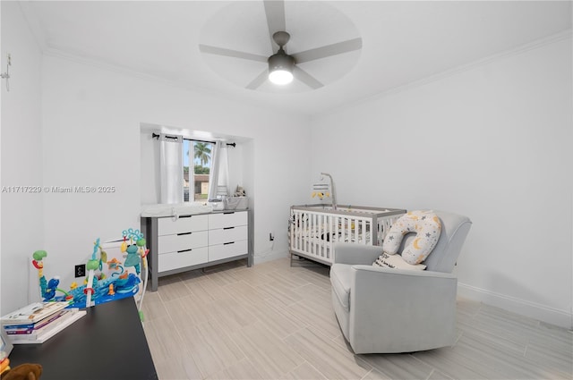 bedroom with ceiling fan, a nursery area, and ornamental molding