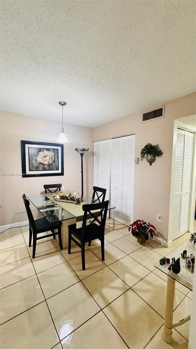 dining room with a textured ceiling and tile patterned floors