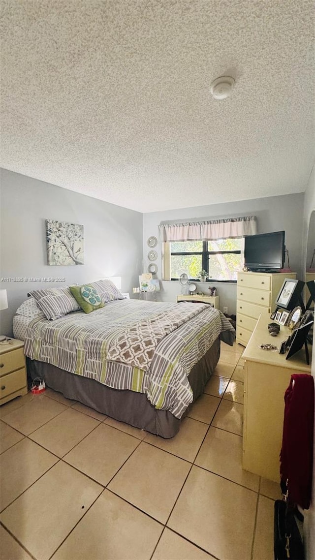 bedroom with light tile patterned floors and a textured ceiling