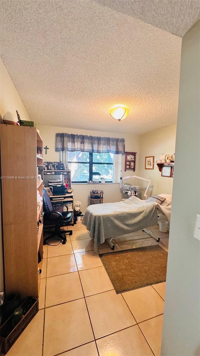 bedroom with tile patterned flooring and a textured ceiling