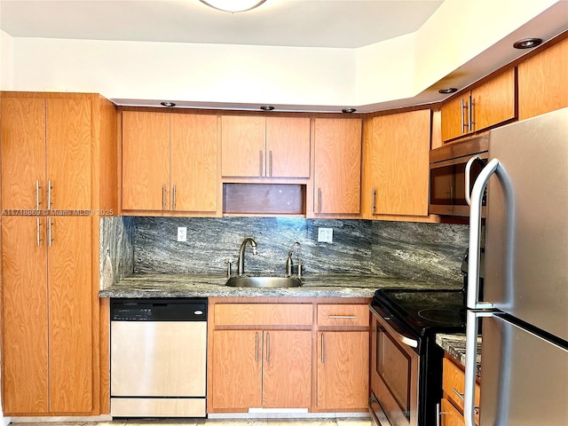 kitchen featuring appliances with stainless steel finishes, a sink, and tasteful backsplash