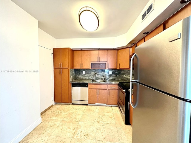 kitchen featuring stainless steel appliances, tasteful backsplash, visible vents, a sink, and baseboards