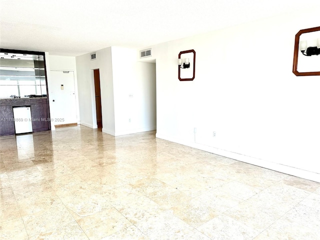 unfurnished room with visible vents and baseboards