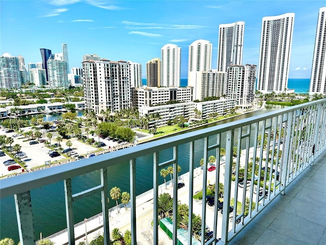 balcony featuring a water view and a city view